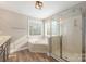 Bathroom with corner soaking tub, shower, and double vanity at 5614 Underwood Ave, Charlotte, NC 28213