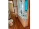 Bathroom with tiled walls, jacuzzi tub, and wood-look flooring at 321 Corriher Heights Ave, China Grove, NC 28023