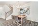 Light-filled dining area with wooden table, gray chairs, and modern chandelier at 4125 Black Ct # 169, Harrisburg, NC 28075