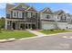 Two-story townhome with gray and stone exterior, two-car garage, and landscaped lawn at 4131 Black Ct # 170, Harrisburg, NC 28075