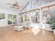 Sunroom with white wicker furniture, vaulted ceiling, and wood flooring at 6833 Charette Ct, Charlotte, NC 28215