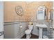 Elegant powder room with pedestal sink, decorative wallpaper and gray wainscoting at 962 Castlewatch Dr, Fort Mill, SC 29708