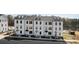 Three-story townhouses with white siding, gray roofs, and small front yards at 13005 Moon Rd # 43, Charlotte, NC 28277