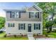 Two-story house featuring gray and beige siding, a dark door, and landscaping at 358 Camden Nw Ct, Concord, NC 28027