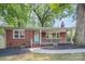 Brick ranch house with light green door, steps, and a shaded yard at 916 Pierson Dr, Charlotte, NC 28205