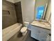 Bathroom with gray tile, a tub, toilet and vanity at 1405 Mara Ave, Gastonia, NC 28052