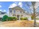 Two-story house with a covered porch, landscaping, and a tree in the front yard at 14217 Green Birch Dr, Pineville, NC 28134