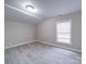 Spacious bedroom with gray wood-look flooring and large window at 208 Oakland Dr, Lowell, NC 28098