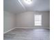 Empty bedroom with gray wood-look floors and a large window at 208 Oakland Dr, Lowell, NC 28098