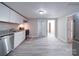 White kitchen with granite countertops, stainless steel appliances, and gray wood-look flooring at 208 Oakland Dr, Lowell, NC 28098