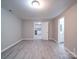 Neutral living space with wood-look flooring and open doorways to adjacent rooms at 208 Oakland Dr, Lowell, NC 28098