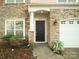 Stone and siding townhome exterior with dark front door, garage, and landscaping at 4641 Craigmoss Ln, Charlotte, NC 28278