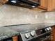 Close-up of the glass top stove, vent hood, and granite countertops at 4641 Craigmoss Ln, Charlotte, NC 28278