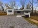 Charming renovated home with fresh white exterior, black roof, and gravel driveway at 555 Old Wilkesboro Rd, Taylorsville, NC 28681