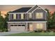 Two-story house with gray siding, beige garage door, and landscaping at 13724 Roderick Dr # 168, Huntersville, NC 28078