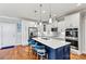 Modern kitchen boasts a center island with blue cabinetry and white countertops at 5019 Pleasant Run Dr, Matthews, NC 28104