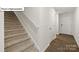 Carpeted staircase with white railing in home at 5149 Hyrule Dr, Charlotte, NC 28262