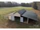Aerial view of a barn with open stalls and a fenced paddock at 7812 Hwy 742 Hwy, Marshville, NC 28103