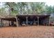 Rustic wooden storage shed with a covered area and various equipment at 7812 Hwy 742 Hwy, Marshville, NC 28103