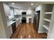 Modern kitchen with white cabinets, stainless steel appliances, and hardwood floors at 112 Mccray Ave, Kannapolis, NC 28081