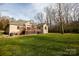 Back view of a brick home with a large deck and grassy yard at 152 Stacybrook Se Dr, Concord, NC 28025