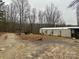 Gravel driveway leading to a manufactured home with a shed and wooded area in the background at 206 Rocky Top Rd, Taylorsville, NC 28681