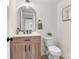 Powder room with wood vanity, modern fixtures, and arched mirror at 5035 Auburndale Rd, Charlotte, NC 28205