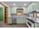 Kitchen with light green cabinets, stainless steel appliances, and tile countertops at 101 Stonehenge Ln, Statesville, NC 28625