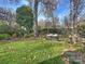 Spacious backyard with lush lawn, mature trees, and patio seating area at 1401 Scotland Ave, Charlotte, NC 28207