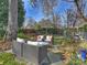 Peaceful backyard retreat with wicker seating, mature trees, and fall foliage at 1401 Scotland Ave, Charlotte, NC 28207