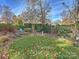 Landscaped backyard with green grass, trees, shrubs, and decorative elements at 1401 Scotland Ave, Charlotte, NC 28207