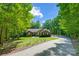 Inviting home with a paved driveway, surrounded by greenery and trees, under a blue sky at 319 Harvard Dr, Albemarle, NC 28001