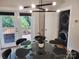 Dining area with glass-top table, modern light fixture, and access to a private deck at 327 Coxe Ave, Charlotte, NC 28208