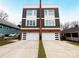 Modern two-story duplex with white garage doors and a wood accent at 327 Coxe Ave, Charlotte, NC 28208