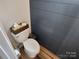 Powder room with a toilet, shiplap walls, and wooden tissue box holder at 327 Coxe Ave, Charlotte, NC 28208