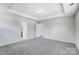 Empty bedroom with gray carpet, white walls, and a tray ceiling at 14902 Tamarack Dr, Charlotte, NC 28278