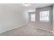 Empty bedroom with neutral walls, carpeting, and two windows at 14910 Tamarack Dr, Charlotte, NC 28278