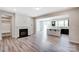 Open-concept living room with fireplace, wood floors, and view of kitchen at 14910 Tamarack Dr, Charlotte, NC 28278