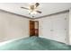 Bedroom with teal carpet, white walls, double closet doors, and open door to another room at 1599 Locustwood Ave, Lancaster, SC 29720