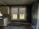 Kitchen with white cabinets, wood-look floor, and windows overlooking the backyard at 440 Rainey Rd, Salisbury, NC 28146