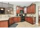 L-shaped kitchen with granite countertops and dark wood cabinets at 5361 Harvest Hill Dr, Harrisburg, NC 28075