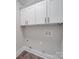 Bright laundry room featuring white cabinets and vinyl flooring at 1308 Pleasant Plains Rd, Matthews, NC 28105