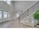 Two-story foyer with hardwood floors, staircase, and a view of the living room at 1312 Pleasant Plains Rd, Matthews, NC 28105