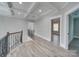 Upstairs hallway with wood floors and an iron railing overlooking the staircase at 1312 Pleasant Plains Rd, Matthews, NC 28105