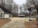 Backyard with a basketball hoop, carport, and wooded area at 13410 Old Camden Rd, Midland, NC 28107