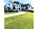 Elegant two-story home with white exterior, manicured lawn, and circular driveway at 18805 Flat Shoals Dr, Cornelius, NC 28031