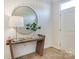 Bright foyer with a stylish wooden console table, round mirror, and a white front door at 1917 Galloway Rd, Charlotte, NC 28262