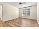 A cozy bedroom featuring wood-look flooring, a ceiling fan, and natural light from two windows at 20105 Henderson Rd # J, Cornelius, NC 28031