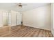 Spacious main bedroom with wood-look flooring, a ceiling fan, and access to the walk in closet and en suite bathroom at 20105 Henderson Rd # J, Cornelius, NC 28031