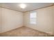 Bright bedroom with a window and neutral carpeting at 207 Christy Ln, Locust, NC 28097